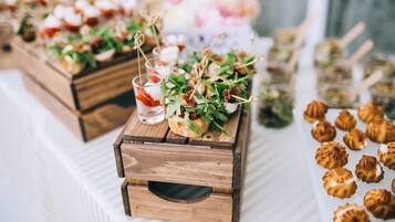 Una mesa con diversas opciones de comida, entre ellas pasteles y una bebida.