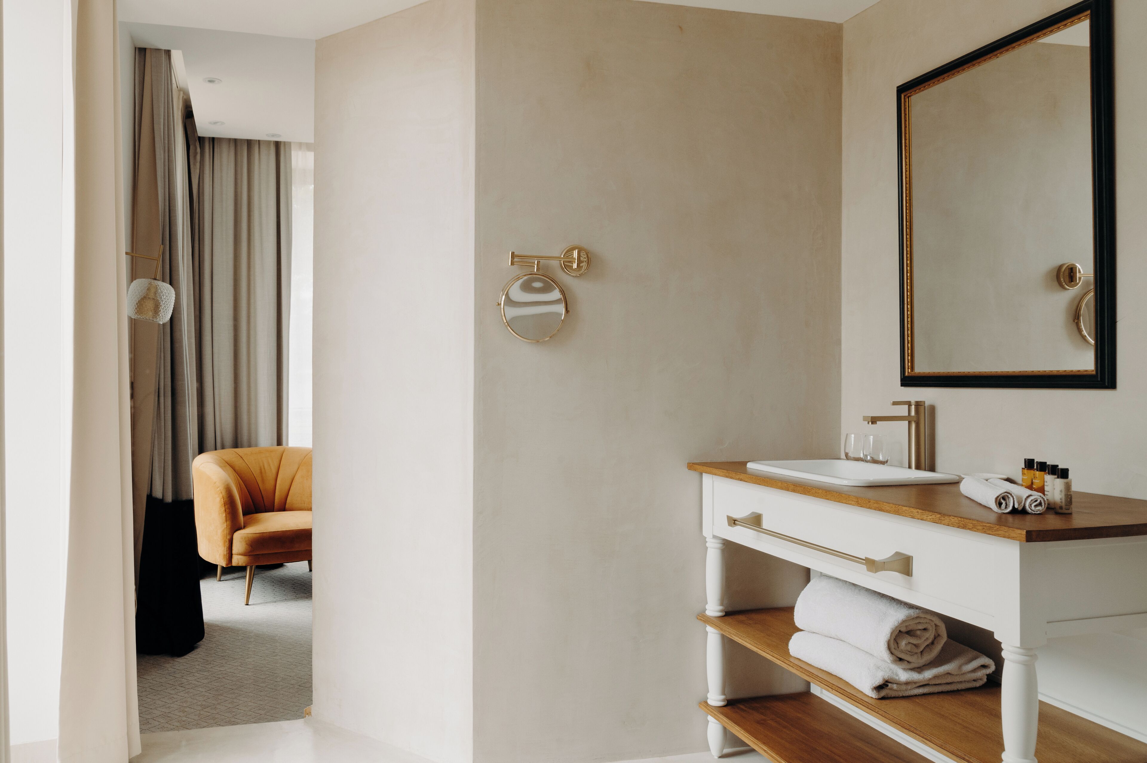 A modern bathroom with a white vanity, a large mirror, and a towel rack.
