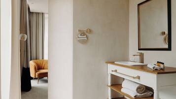 A modern bathroom with a white vanity, a large mirror, and a towel rack.