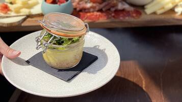 Una persona sosteniendo un frasco con verduras encurtidas sobre un plato.