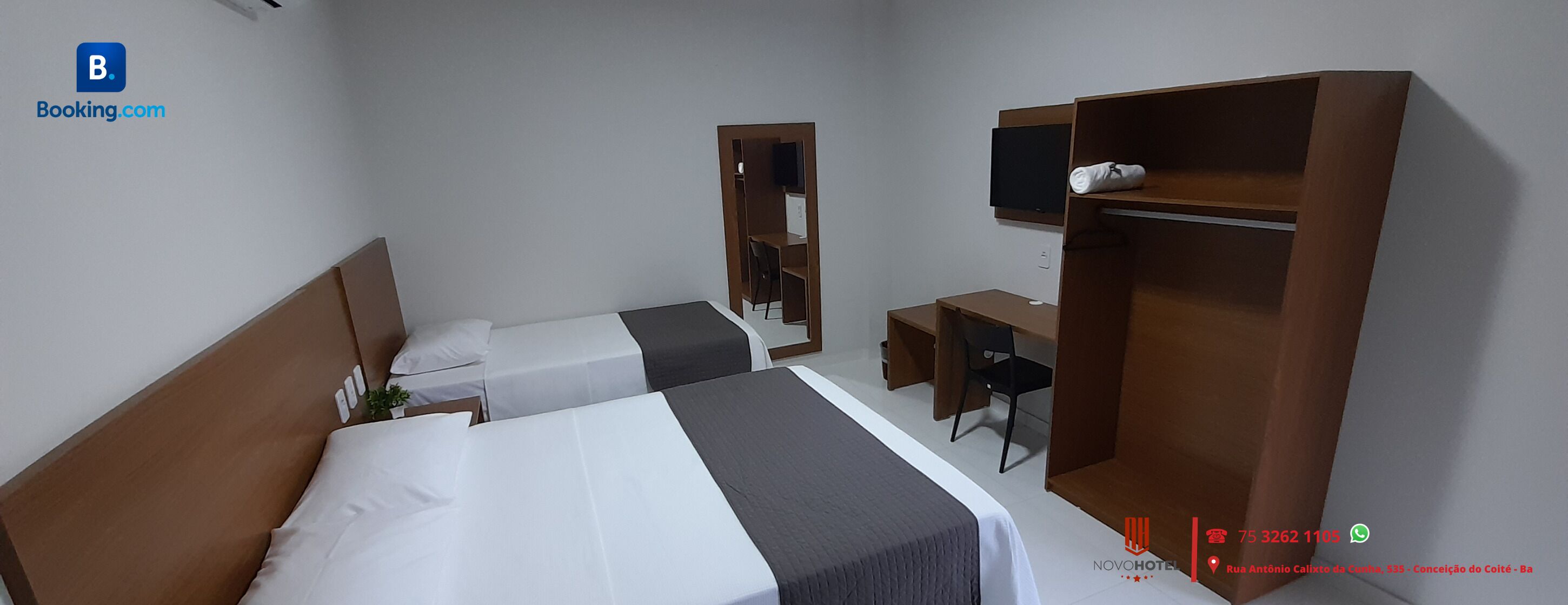 Een hotelkamer met twee enkele bedden, een bureau, een stoel, een televisie en een kledingkast.