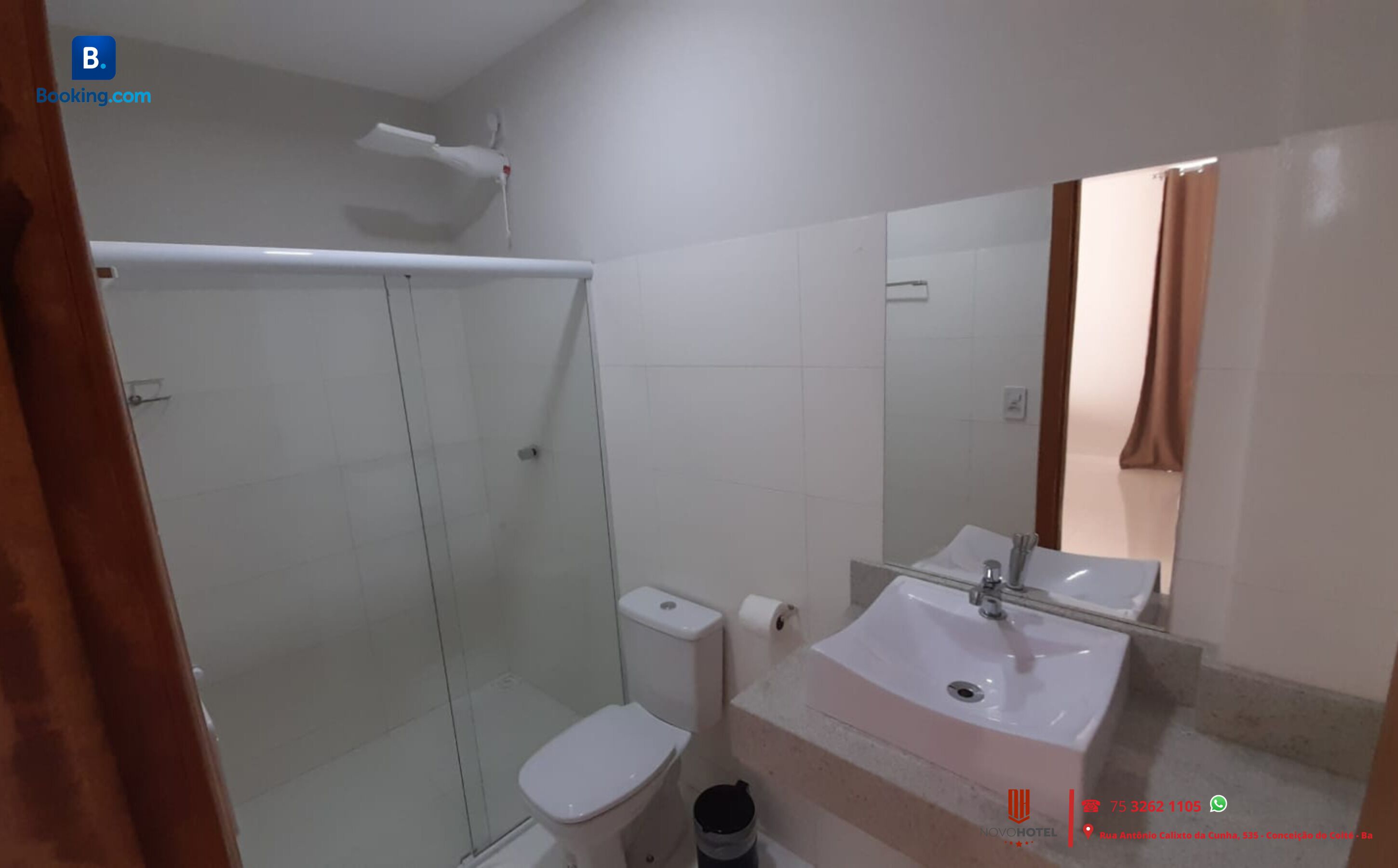 A bathroom with a glass-enclosed shower, a toilet, a sink, and a mirror.