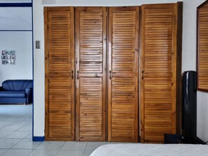 A bedroom with a bed, a blue sofa, and a wooden wardrobe with two doors. - Entire Homy apartment for you, 5 min SJO Airport (Alajuela)