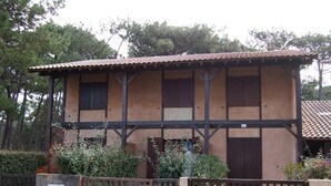 Um edifício de dois andares com telhado telhado, vigas de madeira e portão fechado.
