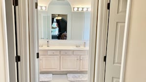 A hallway leading to a bathroom with a vanity, mirror, and lighted vanity area. - Stunning, spacious family home, adjacent to DT Annapolis, (Arnold)
