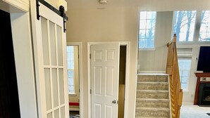 A spacious room with hardwood flooring, a wooden staircase, and a sliding door. - Stunning, spacious family home, adjacent to DT Annapolis, (Arnold)