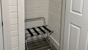 Een kleine, witte kast met een metalen plank en een witte deur.