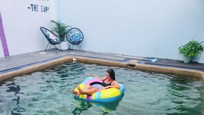 A swimming pool with inflatable toys and lounge chairs. - The Espy Hostel (Cairns)