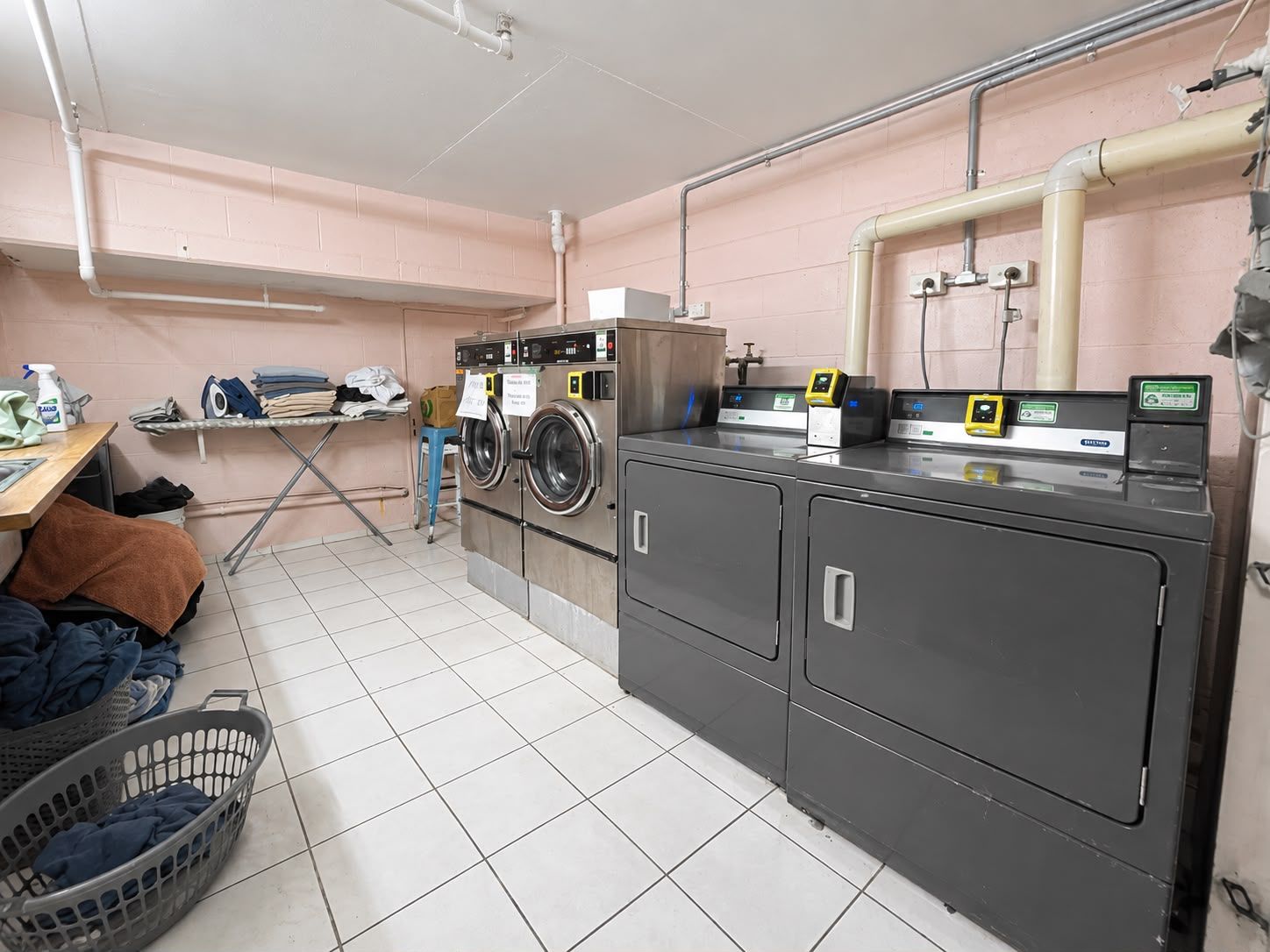A laundry room with washing machines, a drying rack, and a water meter.