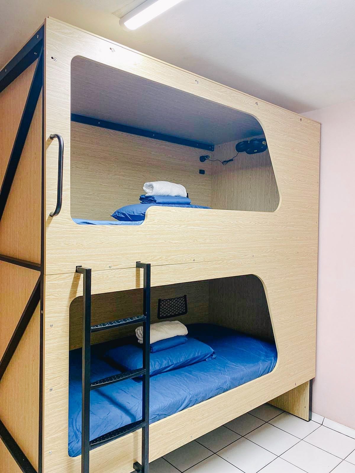 A bunk bed with a ladder, a pull-out desk, and a small shelf.