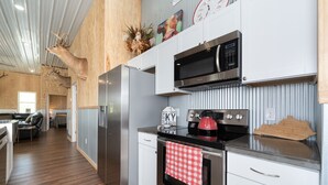 A modern kitchen with stainless steel appliances, a microwave, and a kettle. - 331 Acres of Comfort & Rest, ❤ of the Bluegrass- 12 mins from ARK w/Hot Tub  (Corinth)