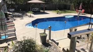 Ein Garten mit Swimmingpool, Terrassenmöbeln und einem Pavillon.