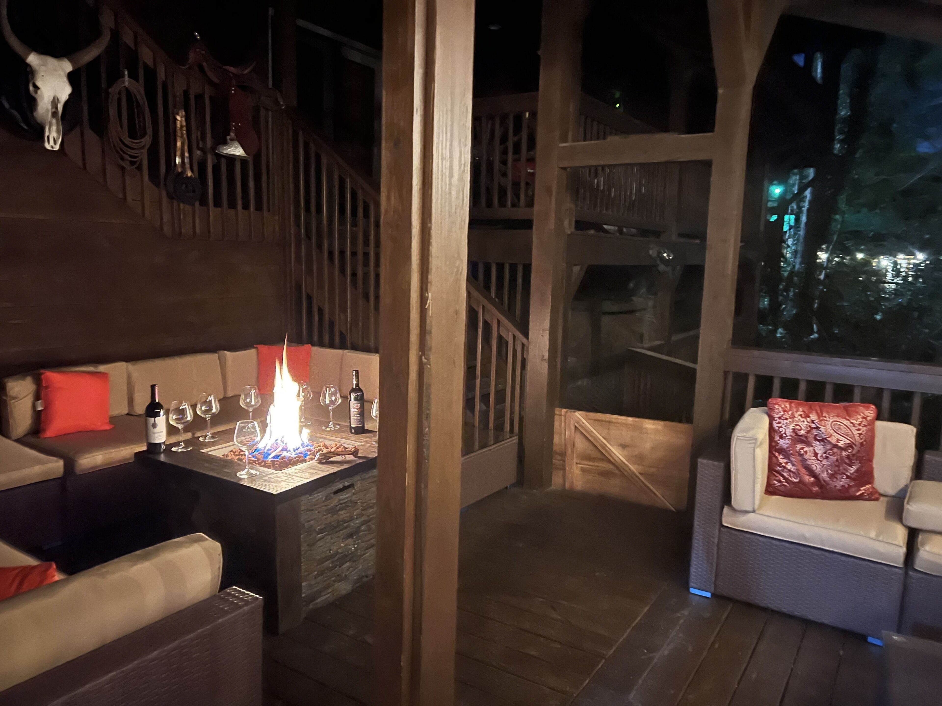 Ein gemütliches Interieur mit Kamin, Sitzecke und Blick durch eine Glastür.