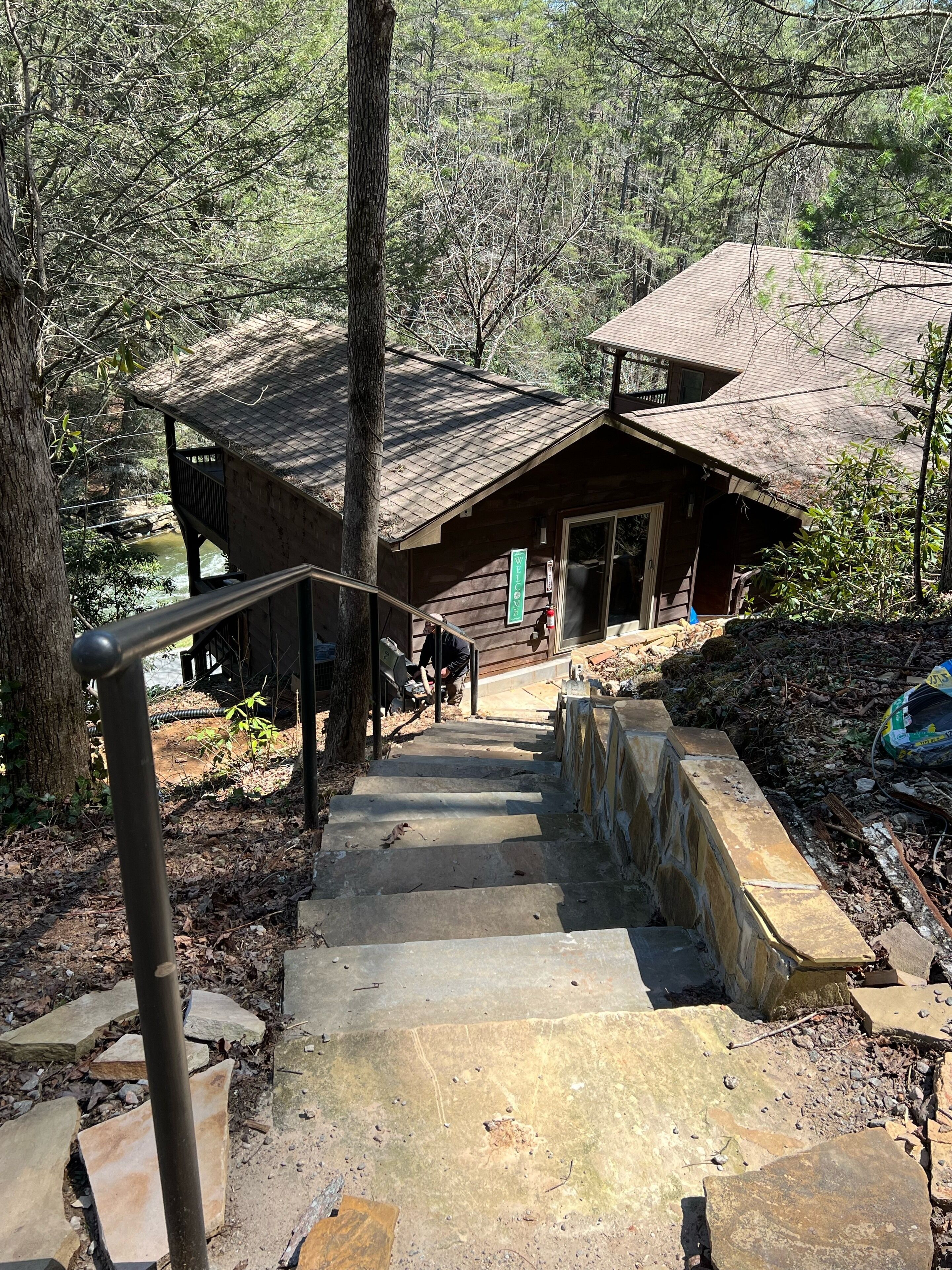 A wooden cabin with a stone staircase leading up to a wooden deck.