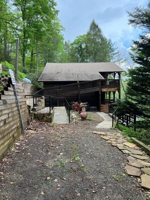 A rustic cabin with a wooden deck and a stone pathway leading to the entrance. - Rustic Cabin on the rapids of Toccoa River  (Blue Ridge)