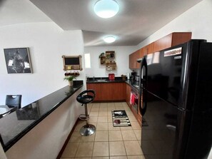 Enjoy cooking in this fully equipped kitchen with a refrigerator, sink, and countertop.