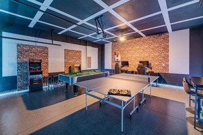 A billiards room with a pool table, a foosball table, and a jukebox. - Colorful Getaway with Home Theater at Encore (Kissimmee)