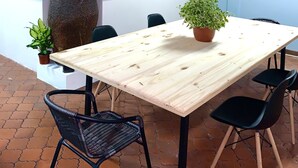 A restaurant with a rustic interior, featuring exposed brick walls, wooden beams, and a large stone planter. - Global House Costa Rica Backpackers (Alajuela)