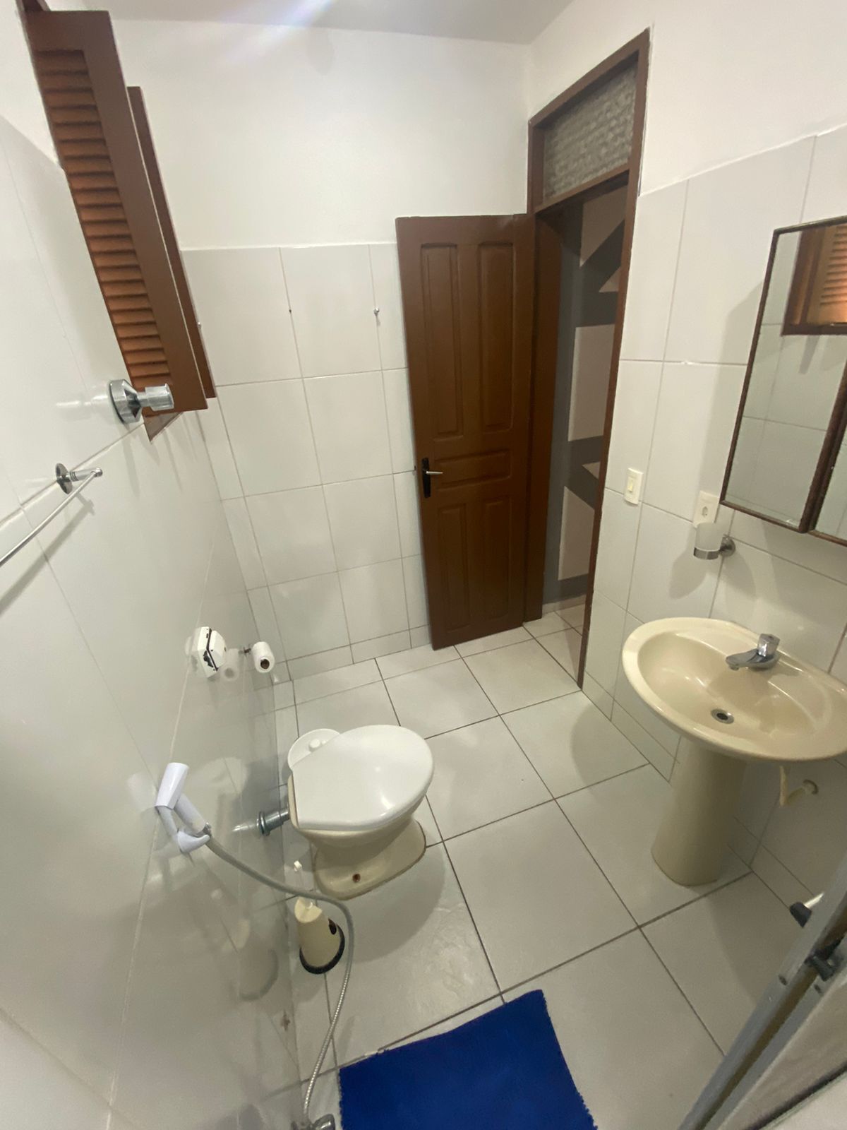 Un baño con inodoro, lavabo y zona de ducha.