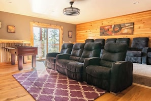 A living room with a fireplace, a sofa, a rug, and a wooden wall.