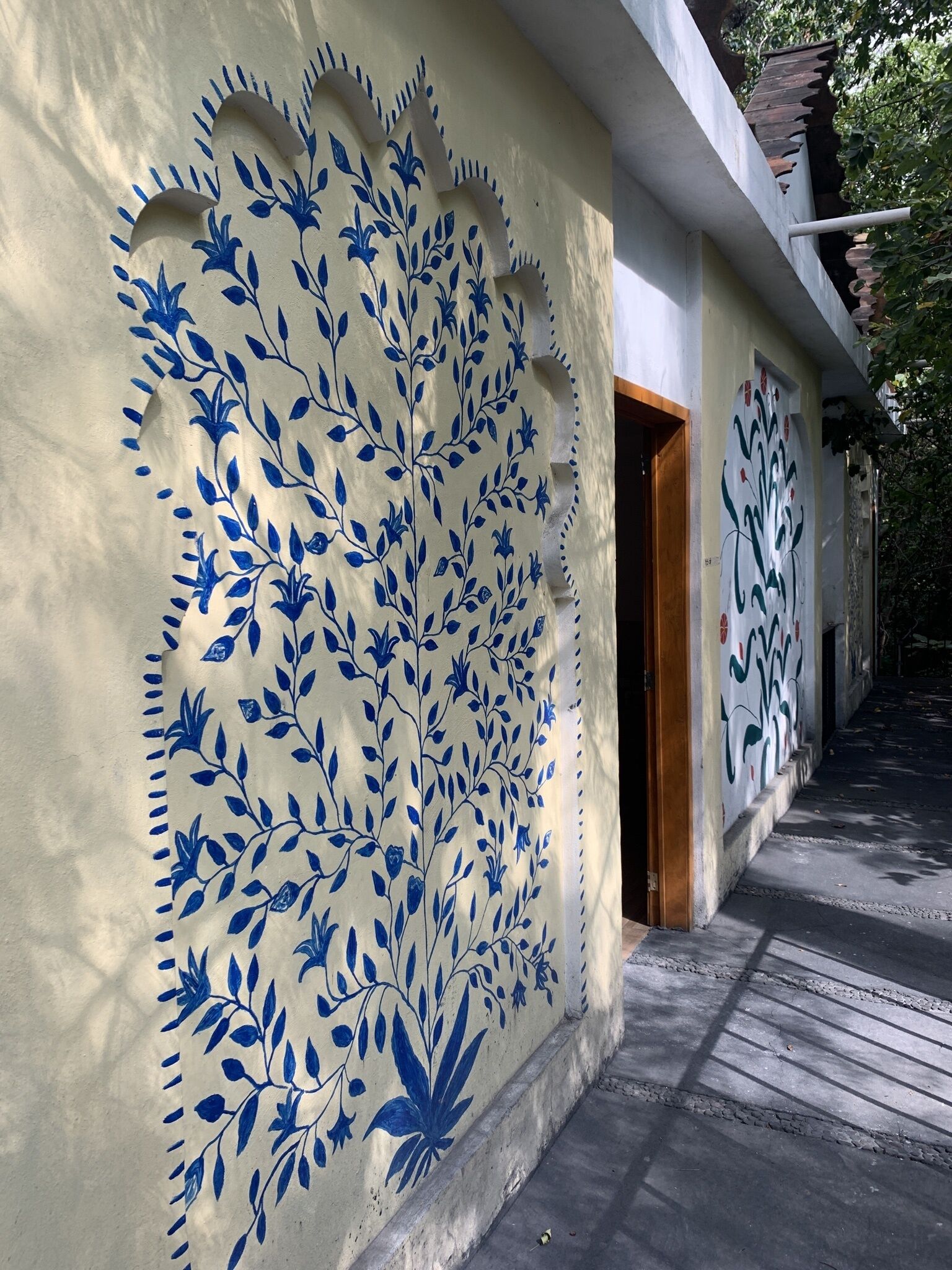 Un bâtiment à la façade de couleur crème ornée de motifs floraux bleus.