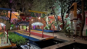 Un espacio exterior colorido con una fuente, bancos y elementos decorativos.