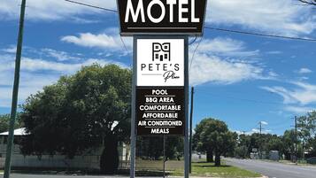 Motel Schild mit Annehmlichkeiten wie Pool, Grillplatz, komfortable und preiswerte Mahlzeiten sowie Klimaanlage.