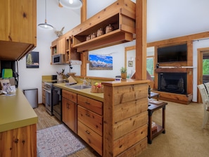 Enjoy cooking in this well-equipped kitchen with a central island, microwave, sink, and stove.