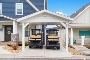 A covered parking area with two golf carts parked side by side.