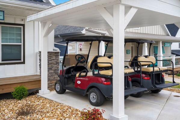 A covered outdoor area with two golf carts parked under a white structure.