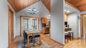A dining area with a wooden table, chairs, and a chandelier.