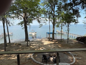 A lakeside view with wooden docks, a covered seating area, and a fire pit.