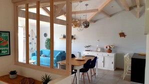 Un espacio habitable moderno con zona de comedor, cocina y vistas a través de un ventanal.
