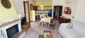 A compact living space with a dining area, kitchen, and a sofa.
