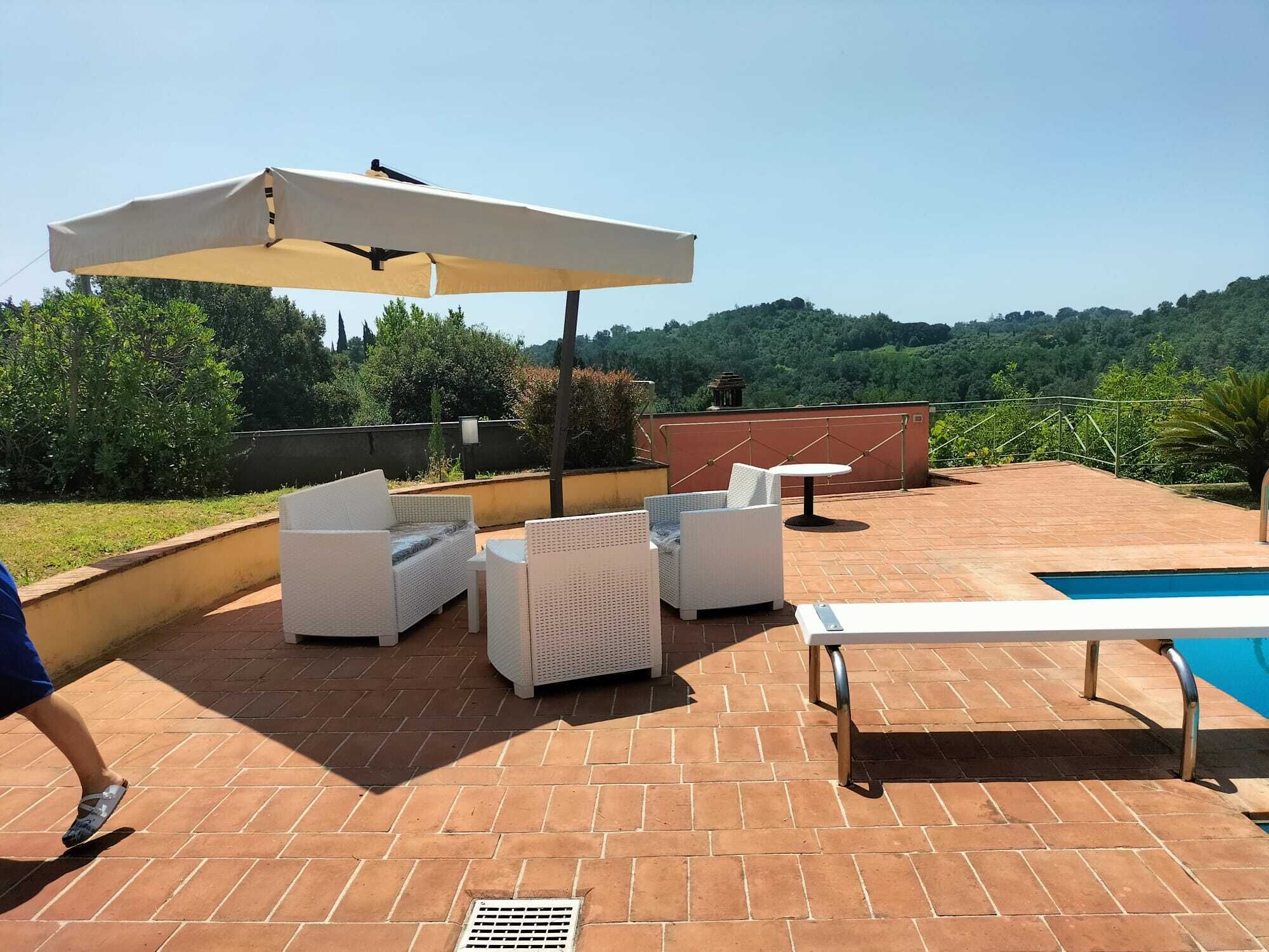 Une terrasse sur le toit, aménagée avec du mobilier d’extérieur, une piscine et offrant une vue sur le paysage environnant.