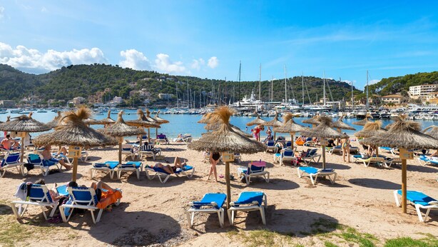 A beach with sun loungers and thatched umbrellas, a marina in the background, and a hilly landscape. - Stunning Apartment "Ca Na Bel" with Private Terrace, Balcony & Wi-Fi (Port de Sóller)