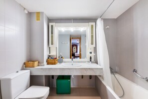 Une salle de bain avec des toilettes, un lavabo et une douche.