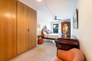 Um quarto com uma cama, um guarda-roupa, uma escrivaninha e uma cadeira.