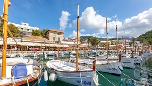 A marina with boats docked, a building with a sign, and a clear sky. - Stunning Apartment "Ca Na Bel" with Private Terrace, Balcony & Wi-Fi (Port de Sóller)