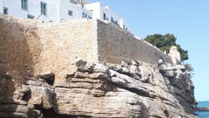 Un edificio costero con fachada de piedra y vista despejada al mar.