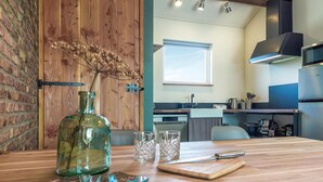 A kitchen with a wooden table, a bottle, and glasses. - 1 bedroom pet friendly home in Grashoek (Grashoek)