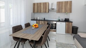 Una cocina moderna con armarios de madera, una mesa de comedor con sillas y un refrigerador.