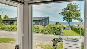 A modern house with a large glass window, a garden, and a view of the sea. - 4 bedroom gorgeous home in Børkop (Børkop)