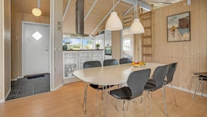 A modern kitchen with white cabinets, a large island, and hanging pendant lights. - 4 bedroom gorgeous home in Børkop (Børkop)