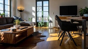Un salon moderne avec une table basse en bois, un canapé en cuir et une grande fenêtre.