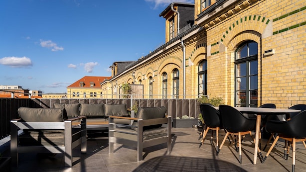 Une terrasse extérieure avec un canapé, des fauteuils et une table.