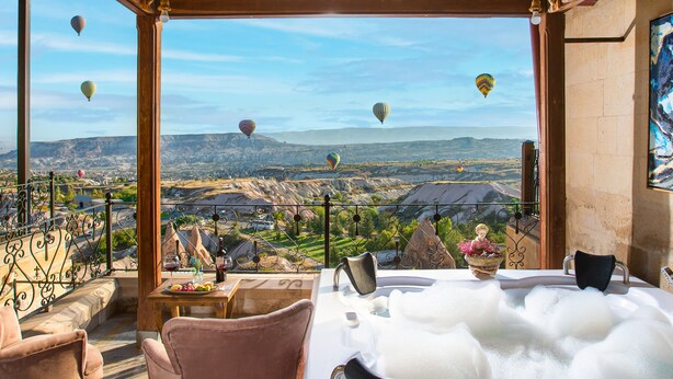 A hot tub with a view of a mountainous landscape and hot air balloons. - Simera In Cappadocia - Special Class (Nevsehir)