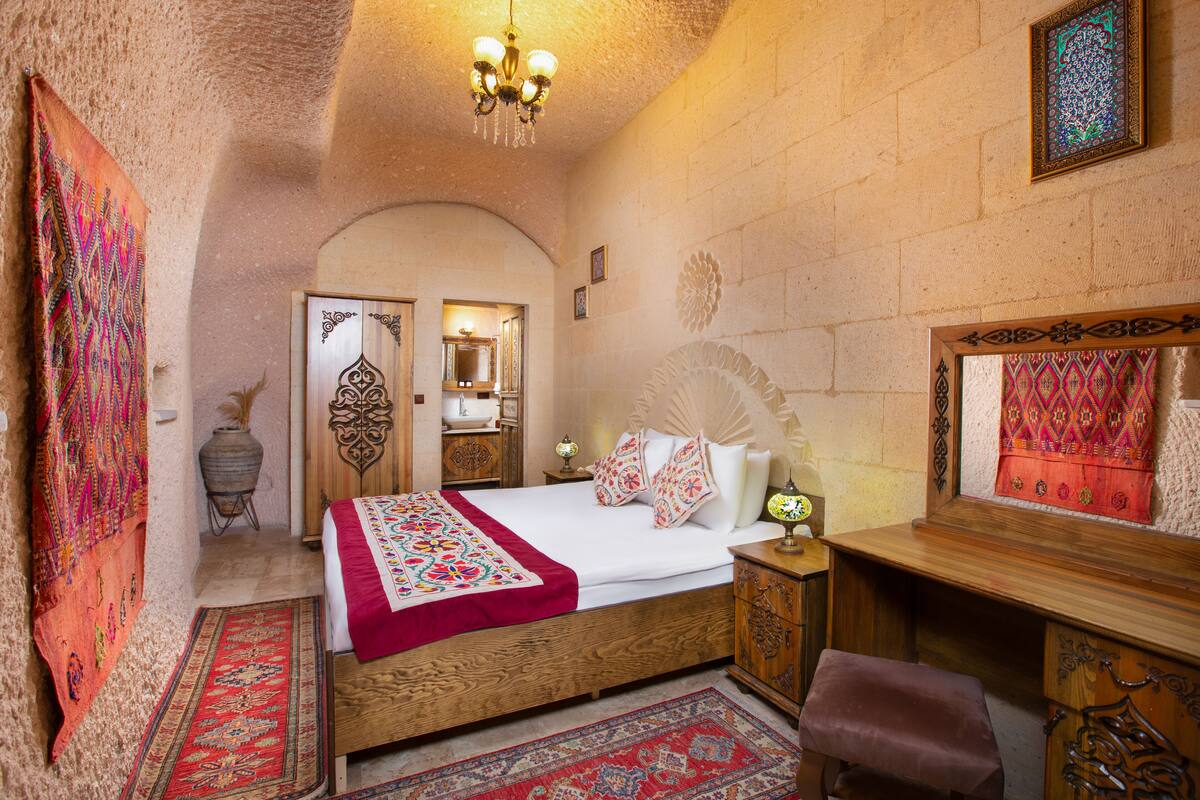 A traditional room with a wooden bed, a desk, and a mirror.
