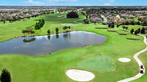 A golf course with bunkers, water hazards, and a pond. - Home2 Suites by Hilton Wildwood the Villages (Wildwood)