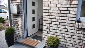 A modern building entrance with a brick facade, a mailbox, and a doormat. - Beautiful vacation apartment near Pietzmoor (Schneverdingen)